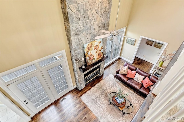 living room featuring ceiling fan, hardwood / wood-style floors, and a high ceiling