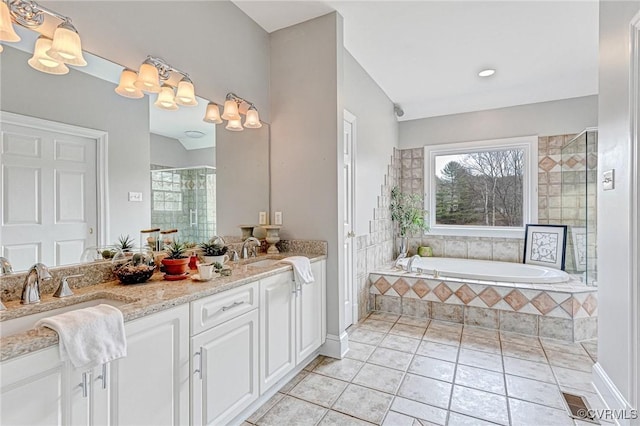 bathroom with tile patterned floors, vanity, and shower with separate bathtub