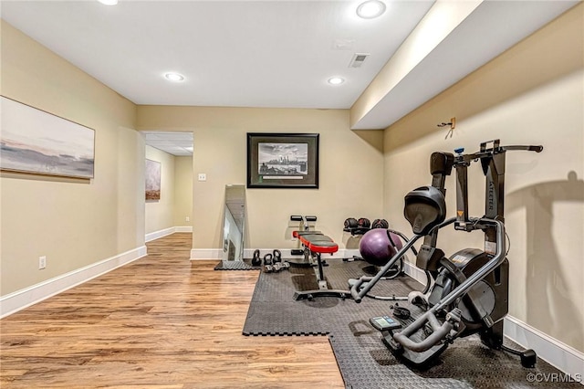 exercise room with light hardwood / wood-style floors