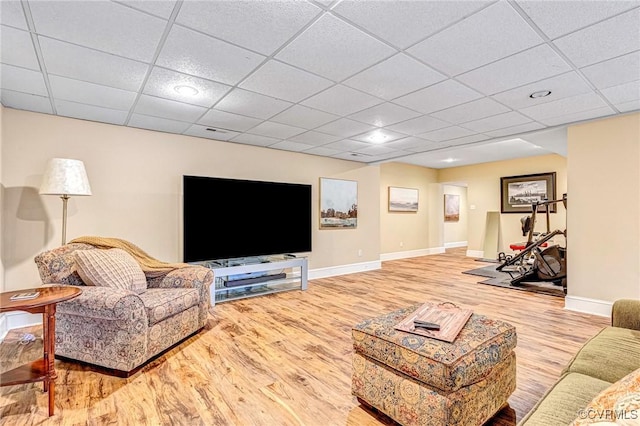 living room with a paneled ceiling and light wood-type flooring