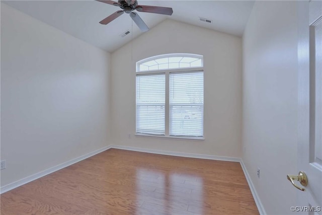 spare room featuring light wood-type flooring, vaulted ceiling, and ceiling fan