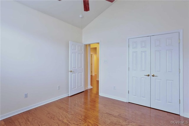 unfurnished bedroom featuring a closet, light hardwood / wood-style flooring, high vaulted ceiling, and ceiling fan