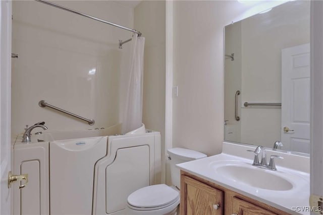 bathroom with vanity, toilet, and a tub