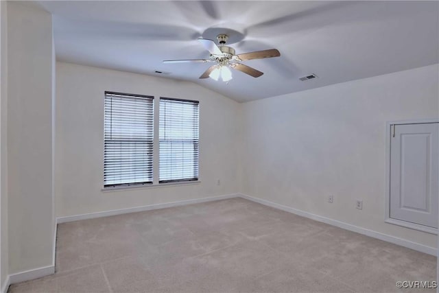 unfurnished room featuring light carpet, vaulted ceiling, and ceiling fan