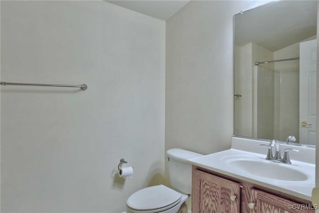 bathroom with vanity, toilet, and a shower