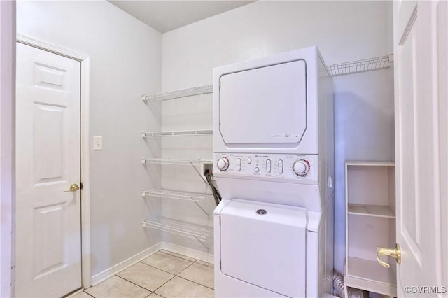 clothes washing area with light tile patterned floors and stacked washer / drying machine