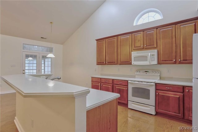 kitchen featuring pendant lighting, a center island, white appliances, and high vaulted ceiling