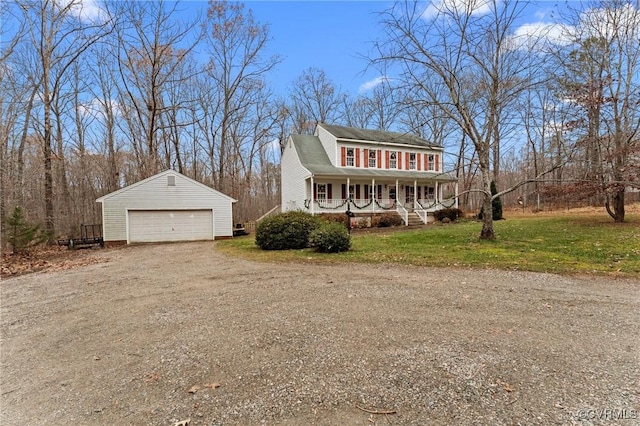 view of front of house featuring a porch, a garage, an outbuilding, and a front lawn