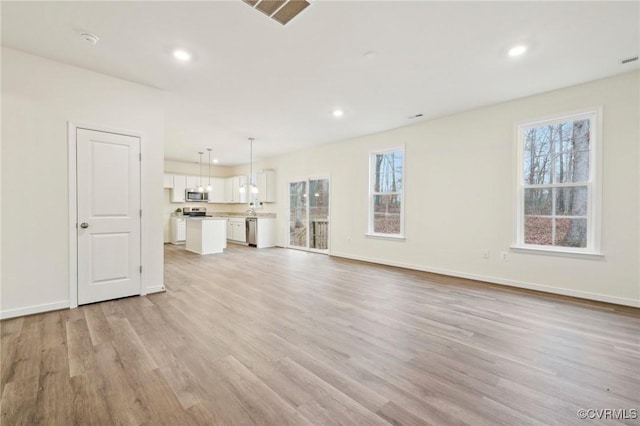 unfurnished living room featuring light hardwood / wood-style flooring and a wealth of natural light