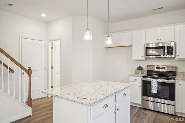 kitchen featuring dark hardwood / wood-style floors, a kitchen island, white cabinetry, and stainless steel appliances