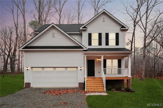 view of front of home with covered porch, a garage, and a lawn