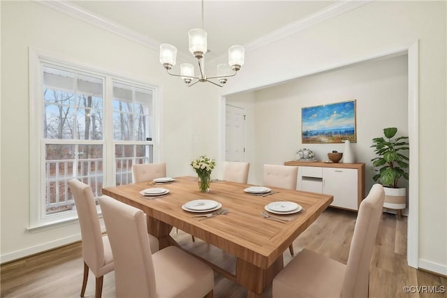 dining room with ornamental molding, a chandelier, and light hardwood / wood-style floors