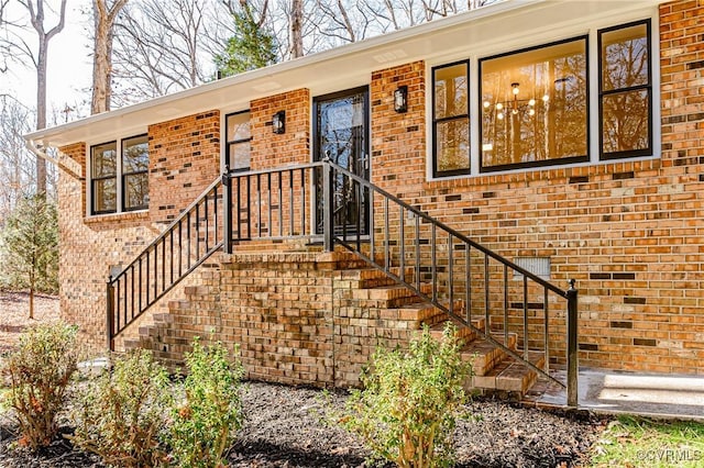 doorway to property featuring brick siding