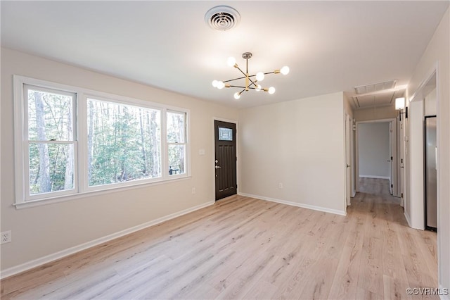 foyer with visible vents, baseboards, light wood-style floors, and a chandelier