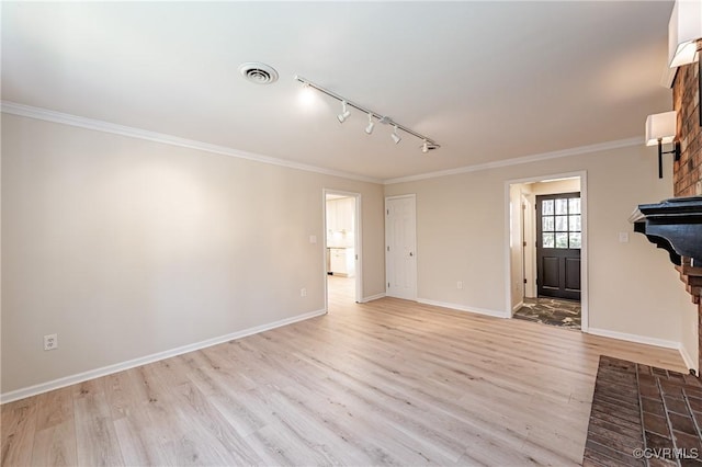 interior space featuring visible vents, crown molding, baseboards, light wood-style flooring, and rail lighting