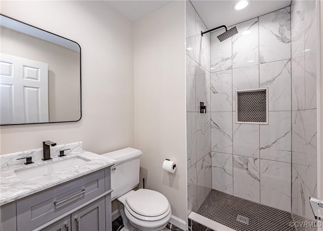 full bathroom with visible vents, toilet, a marble finish shower, baseboards, and vanity