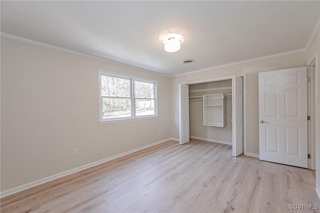 unfurnished bedroom featuring a closet, baseboards, light wood-style floors, and crown molding