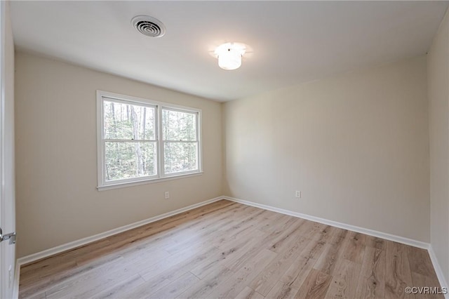 unfurnished room with baseboards, visible vents, and light wood finished floors