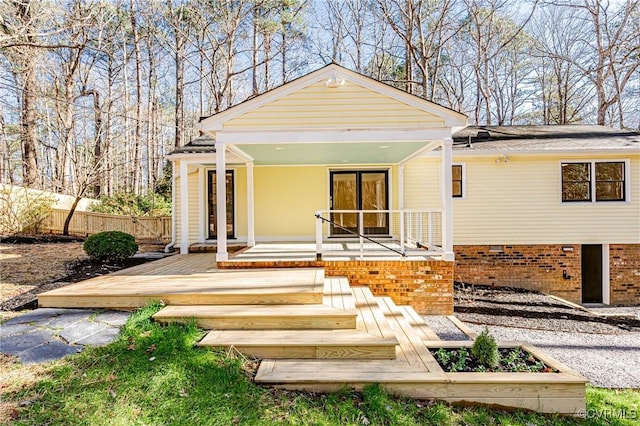 view of front of house featuring crawl space, covered porch, and fence