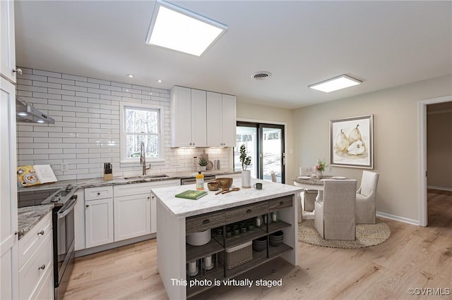 kitchen featuring backsplash, open shelves, electric stove, white cabinets, and a sink