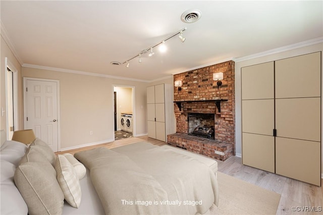 bedroom featuring washer and clothes dryer, visible vents, light wood finished floors, and crown molding