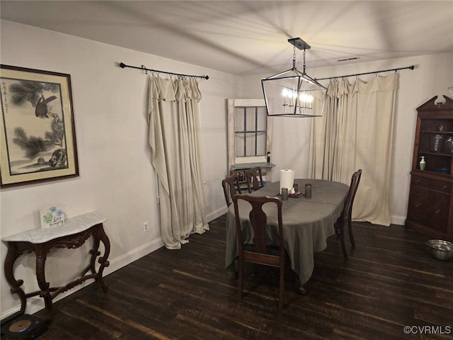 dining space featuring dark hardwood / wood-style floors and a chandelier