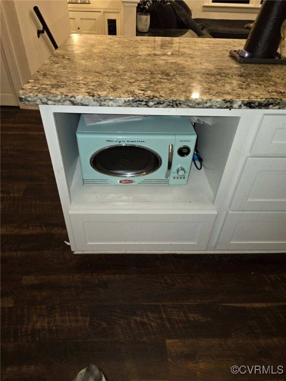 room details featuring white cabinetry, dark hardwood / wood-style floors, and light stone counters