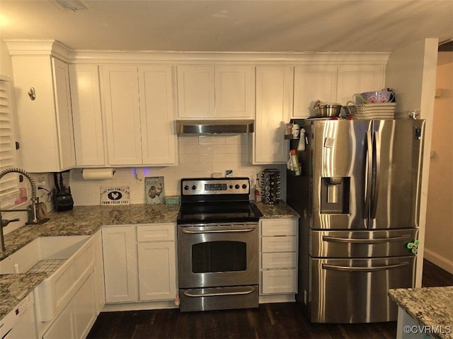 kitchen with light stone countertops, appliances with stainless steel finishes, dark hardwood / wood-style floors, and white cabinets