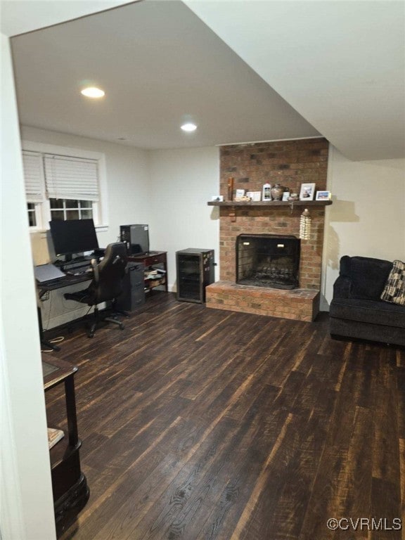 office area featuring a brick fireplace and dark hardwood / wood-style flooring