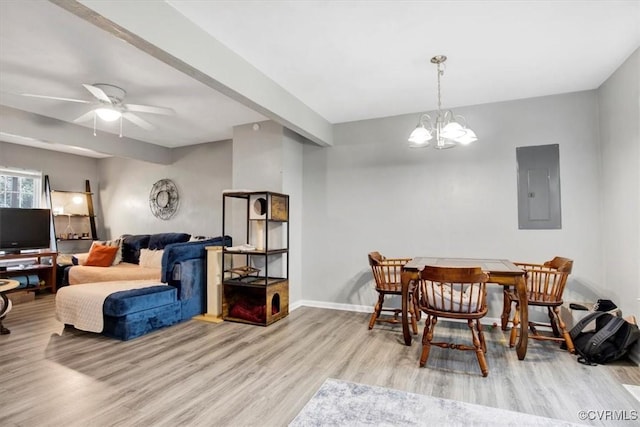 dining room with ceiling fan with notable chandelier, electric panel, beamed ceiling, and light hardwood / wood-style flooring