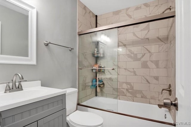 full bathroom featuring vanity, enclosed tub / shower combo, and toilet