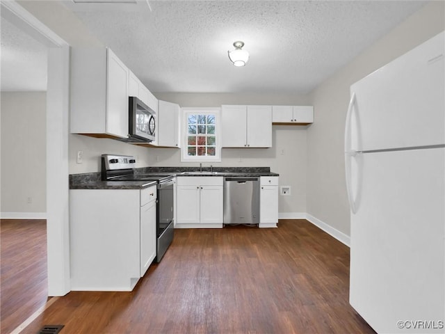 kitchen with dark wood-type flooring, white cabinets, sink, a textured ceiling, and stainless steel appliances