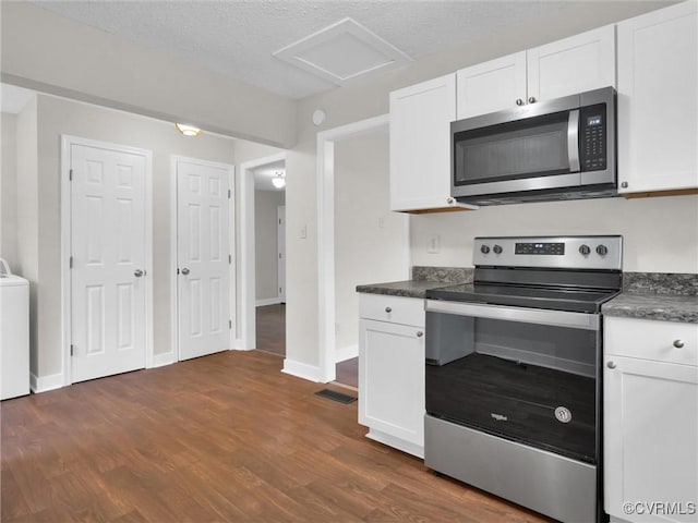 kitchen with dark hardwood / wood-style flooring, washer / clothes dryer, a textured ceiling, white cabinets, and appliances with stainless steel finishes