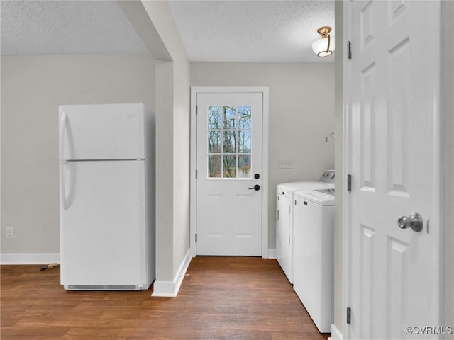 laundry room with light hardwood / wood-style flooring, a textured ceiling, and independent washer and dryer