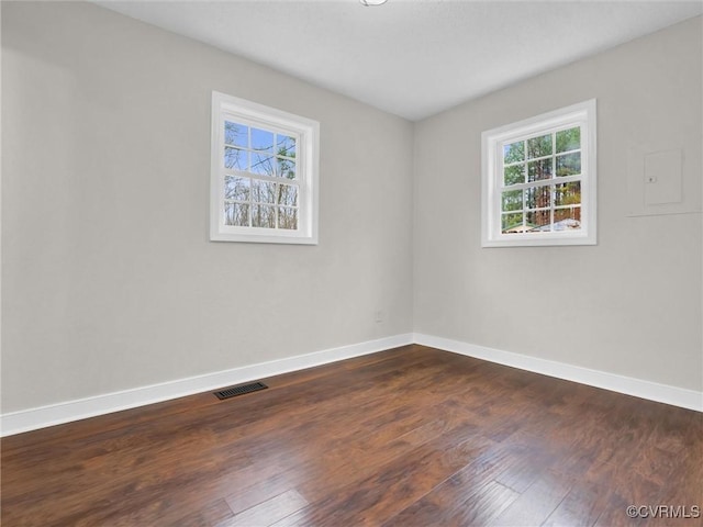 unfurnished room with a wealth of natural light and dark hardwood / wood-style flooring