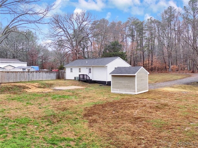 rear view of property featuring a lawn and a shed