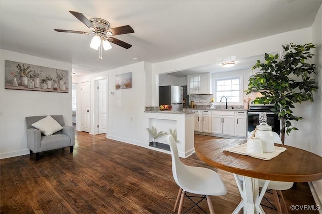 dining space featuring dark hardwood / wood-style flooring, ceiling fan, and sink