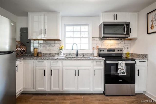 kitchen featuring hardwood / wood-style flooring, white cabinetry, sink, and appliances with stainless steel finishes