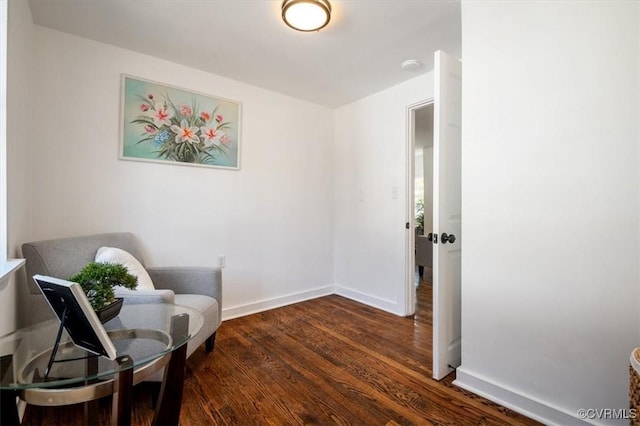 sitting room with dark wood-type flooring