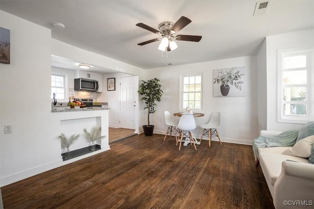 living room featuring dark hardwood / wood-style floors and ceiling fan