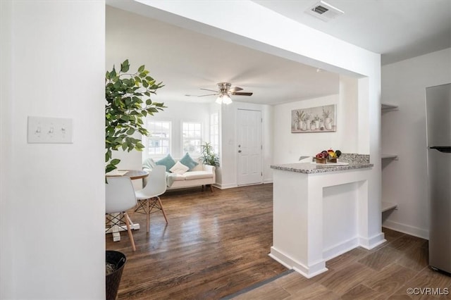 kitchen with dark hardwood / wood-style floors, stainless steel refrigerator, and ceiling fan