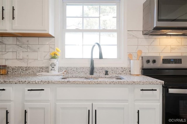 kitchen featuring light stone countertops, sink, white cabinets, and stainless steel appliances