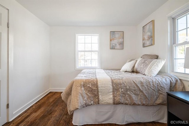 bedroom featuring multiple windows and dark hardwood / wood-style floors