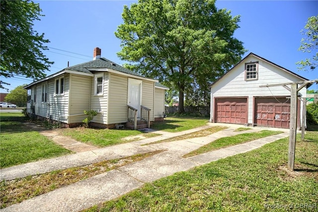 view of front of property with an outbuilding, a front yard, and a garage