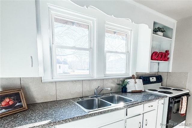 kitchen featuring decorative backsplash, range with electric stovetop, white cabinets, and sink