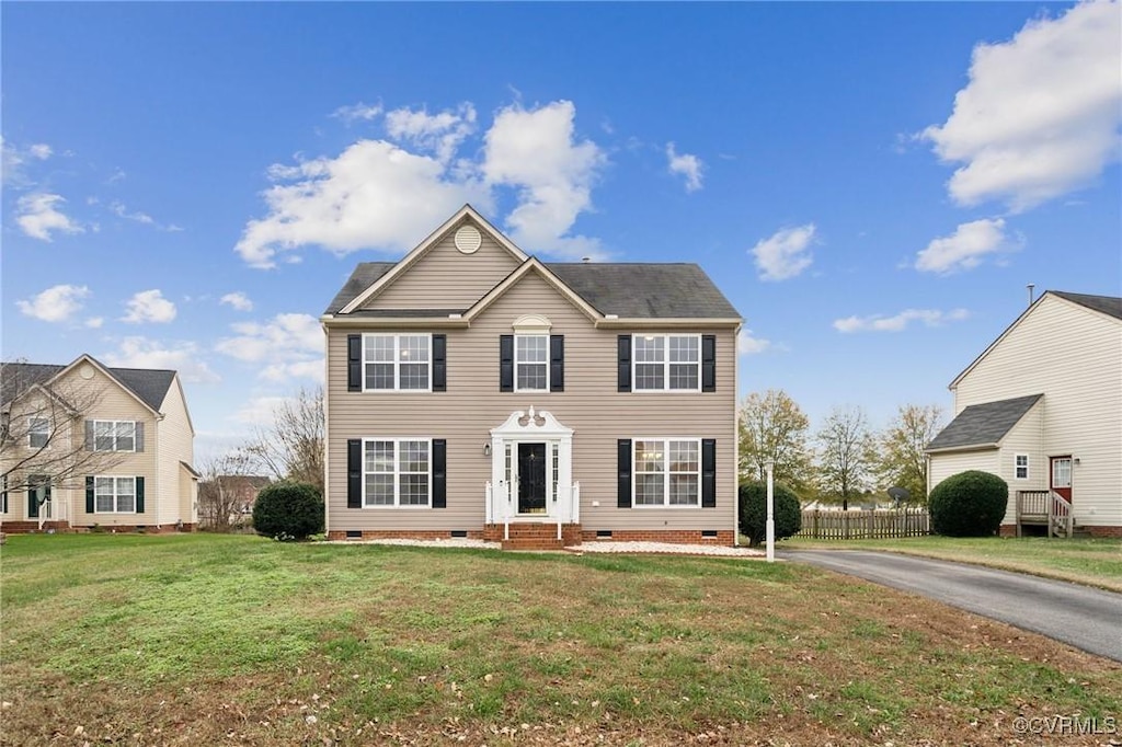 colonial inspired home with a front lawn