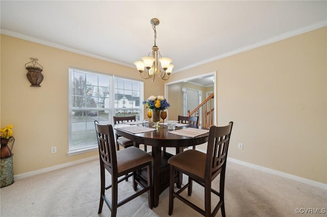 dining room featuring a chandelier, crown molding, and light colored carpet