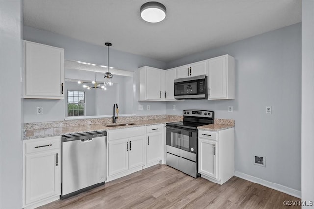 kitchen with white cabinetry, sink, light hardwood / wood-style floors, and appliances with stainless steel finishes