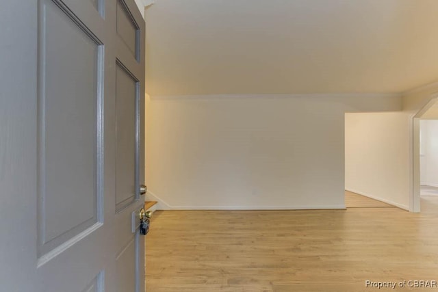 spare room with crown molding and light hardwood / wood-style flooring