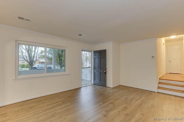 spare room featuring crown molding and light hardwood / wood-style flooring